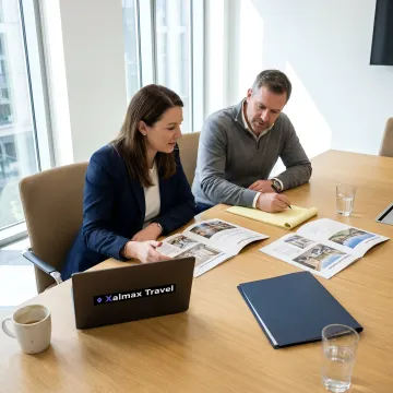 Two colleagues reviewing conference venue floor plans and a proposal on a laptop